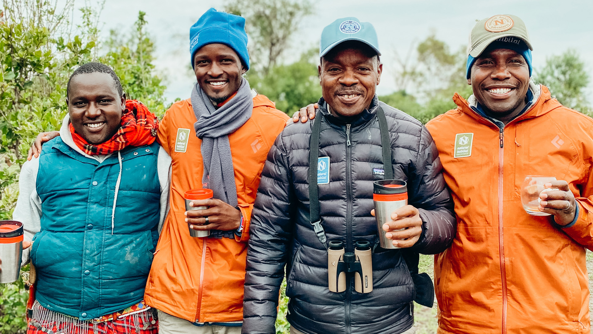 Group photo including a Maasai Tribe member, a Nat Hab Expedition Leader and local guides. Nat Hab’s Mara East Camp—Mara Conservancy, Maasai Mara National Reserve.